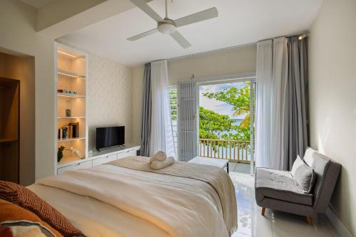a bedroom with a bed and a chair and a window at Amarea Beach Front Appartment or Studio in Richeterre