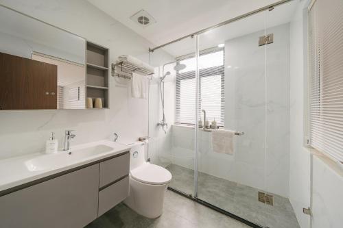 a white bathroom with a toilet and a shower at San Hanoi Hotel & Gaming in Hanoi