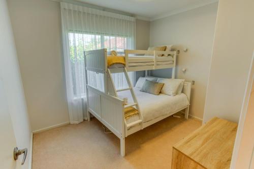 a bunk bed in a small room with a bed at Ibis Rest Beach House in Geographe