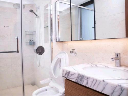 a bathroom with a shower and a toilet and a sink at Happy Hours in Shenzhen