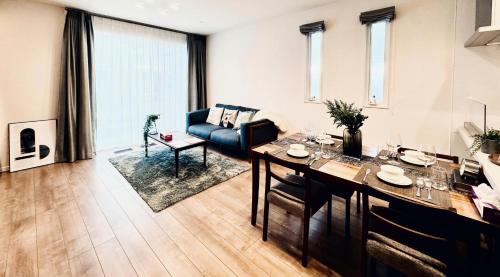 a living room with a table and a blue couch at Akikawa Koshi 3 プレミアム鉄骨 一棟貸切ヴィラ in Yuge