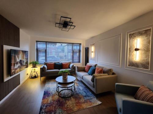 a living room with two couches and a table at Kashkana Haven - Blackburn in Cherry Tree