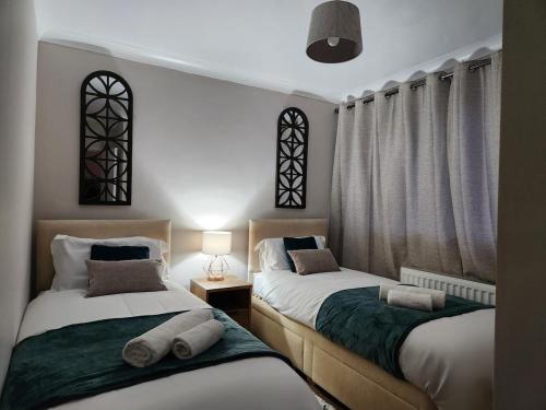 two twin beds in a room with windows and curtains at Kashkana Haven - Blackburn in Cherry Tree