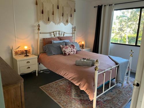 a bedroom with a bed and a window at Urunga Fisherman's Cottage - pets ok 15 mins Coffs in Urunga