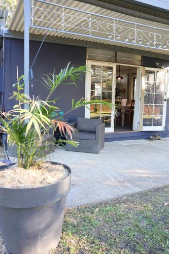 a house with a couch in front of it at Urunga Fisherman's Cottage - pets ok 15 mins Coffs in Urunga