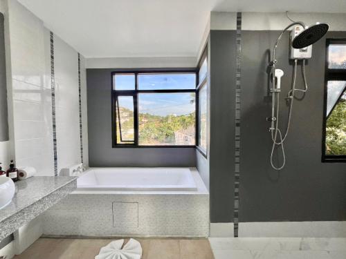 a bathroom with a bath tub and a window at Serenity by Peace Garden, Koh Samui in Bangrak Beach