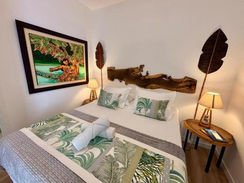 a bedroom with a bed with a painting on the wall at Te mana Dream apartment in Paea