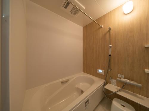 a bathroom with a bath tub and a toilet at 新築貸し切り宿 Karatsu House A in Karatsu