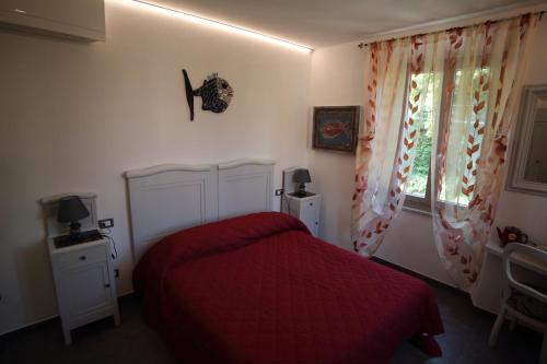 a bedroom with a red bed and a window at 5 TERRE PELAGOS in Manarola