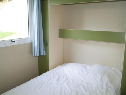a bedroom with a white bed and a window at Chalet avec terrasse - 2 pers. - API-1-52-1592 in Saint-Girons