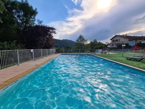 a large swimming pool with blue water in a yard at Chalet avec terrasse - 2 pers. - API-1-52-1592 in Saint-Girons