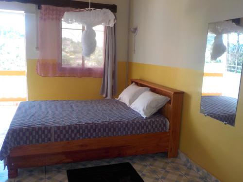 ein kleines Schlafzimmer mit einem Bett und einem Fenster in der Unterkunft Rem Hotel in Fianarantsoa