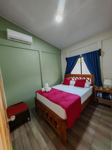 a bedroom with a large bed with a red blanket at Villa Tucano in Fortuna