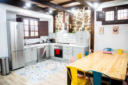 a kitchen with a wooden table and a wooden table and a table and a kitchen at Casa Dana, Losar de la Vera in Losar de la Vera