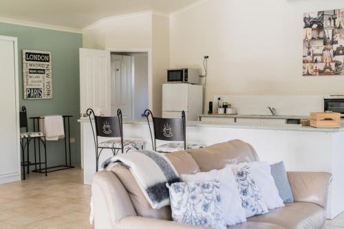 a living room with a couch and a kitchen at Granite Gardens Cottages & Lake Retreat in Stanthorpe