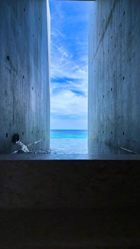 a view of the ocean through a concrete wall at MERIVAS MOTOBU -Ocean View Sauna Villa- in Motobu