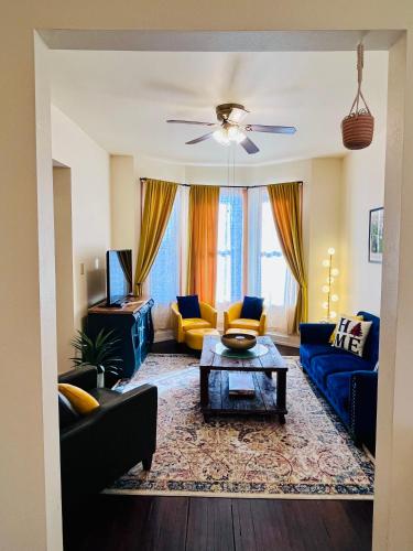 a living room with blue couches and a table at Relaxing Townhouse Downtown Dubuque in Dubuque