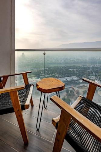 a balcony with benches and a table and a view at PuntaAcero Fundidora y Cintermex in Monterrey