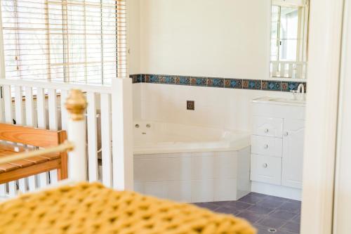 a bathroom with a bath tub and a sink at Granite Gardens Cottages & Lake Retreat in Stanthorpe