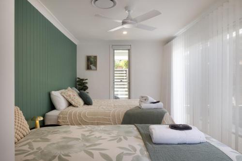 two beds in a room with green walls at Monty's House in Montville