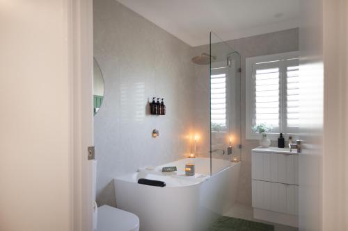 a white bathroom with a tub and a toilet at Monty's House in Montville