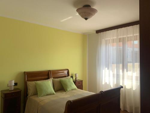 a bedroom with a bed with green walls and a window at Casa Vacanze a Luino - Casa di Adele in Luino