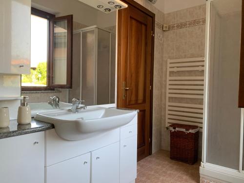 a white bathroom with a sink and a mirror at Casa Vacanze a Luino - Casa di Adele in Luino