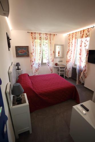 a bedroom with a red bed and a desk at 5 TERRE PELAGOS in Manarola
