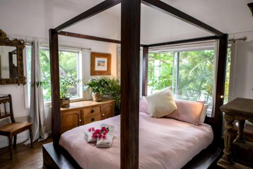 a bedroom with a four poster bed with flowers on it at Jaspers Apartments in Brunswick Heads