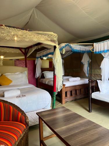 a bedroom with two bunk beds and a table at Eco Mara Tented Camp in Ololaimutiek
