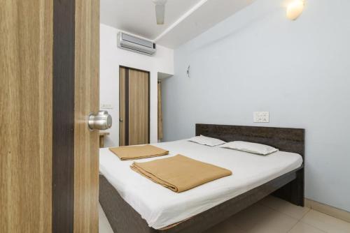 ein Schlafzimmer mit einem Bett, bezogen mit weißen Laken und Handtüchern in der Unterkunft Hotel Pariwar in Aurangabad