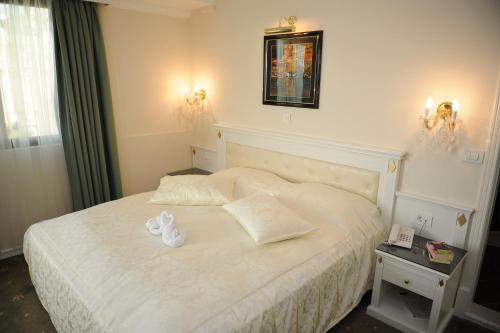 a bedroom with a bed with two white towels on it at Millenium Palace in Ohrid