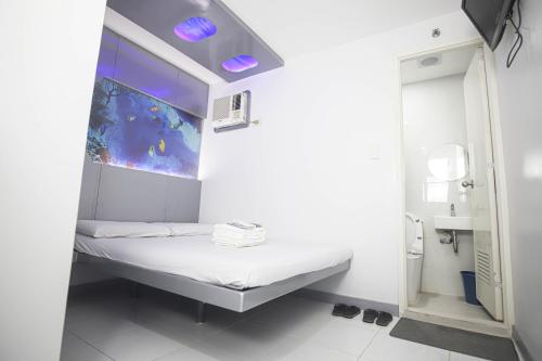 a small hospital room with a bed and a mirror at Astrotel Calamba in Calamba