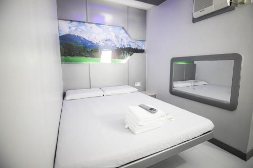 a white room with a bed and a mirror at Astrotel Calamba in Calamba