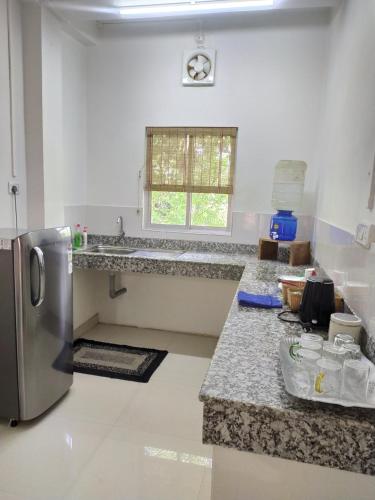 a kitchen with granite counter tops and a stainless steel refrigerator at Viki homestay in Dimapur