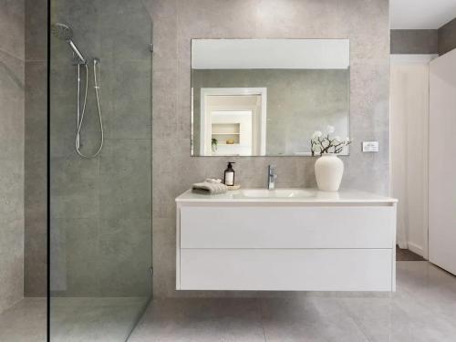 a bathroom with a white sink and a mirror at Capri Garden Stay in Gold Coast