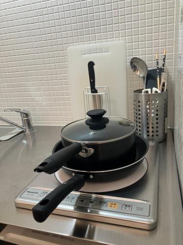 a frying pan sitting on top of a stove at TAKETO STAY Osakajo in Osaka