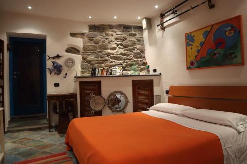 een slaapkamer met een bed en een stenen muur bij La Casina della Tagià in Manarola