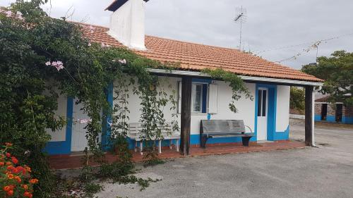 a blue and white house with a bench in front at Casa da Felicidade in Pataias