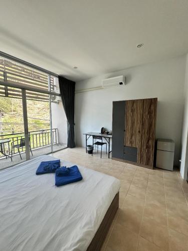 a bedroom with a bed and a table with a desk at Kata Sea Blue in Kata Beach