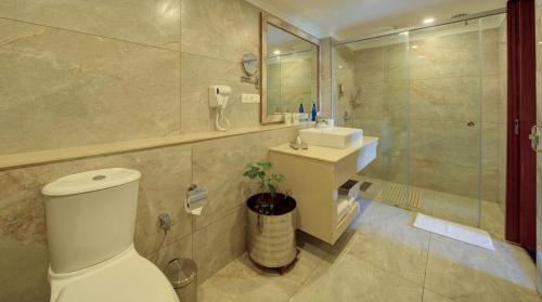 a bathroom with a toilet and a sink and a shower at Hotel Tamilnadu Pandiyan Madurai in Madurai