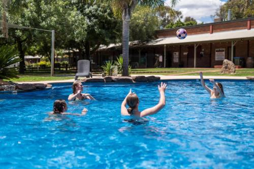 a group of children playing with a volley ball in a swimming pool at Tasman Holiday Parks - Merool on the Murray in Echuca