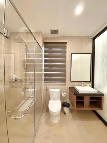 a bathroom with a toilet and a sink and a shower at Leto Hotel Central Sunset Town in Phú Quốc