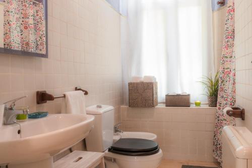 a bathroom with a white toilet and a sink at Casa Rural La Rana in Nava de Francia