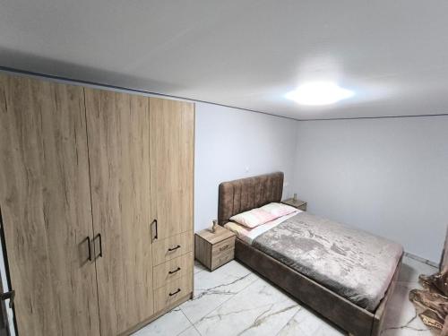 a bedroom with a bed and a large wooden cabinet at Glyki Canyon Bungalow in Antimácheia