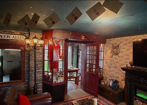 a living room with cards hanging from the ceiling at Quidditch Quarters Themed Property in Garston