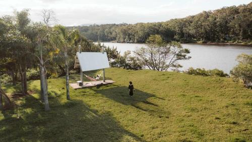 a person walking on a hill near a lake at Picturesque Barn located on the Shoalhaven River in Nowra