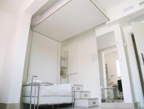 Habitación blanca con espejo y silla en Funway Academic Resort, en Madrid