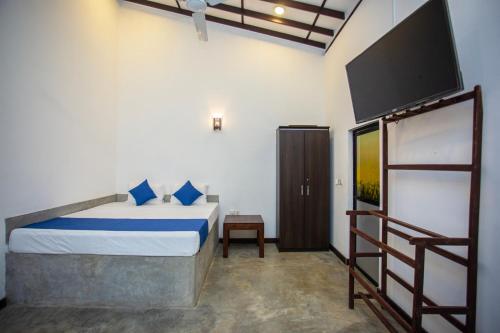a bedroom with a bed and a flat screen tv at Noha Villa in Talpe