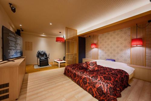 a hotel room with a bed and a tv at Hotel FLOW in Misato